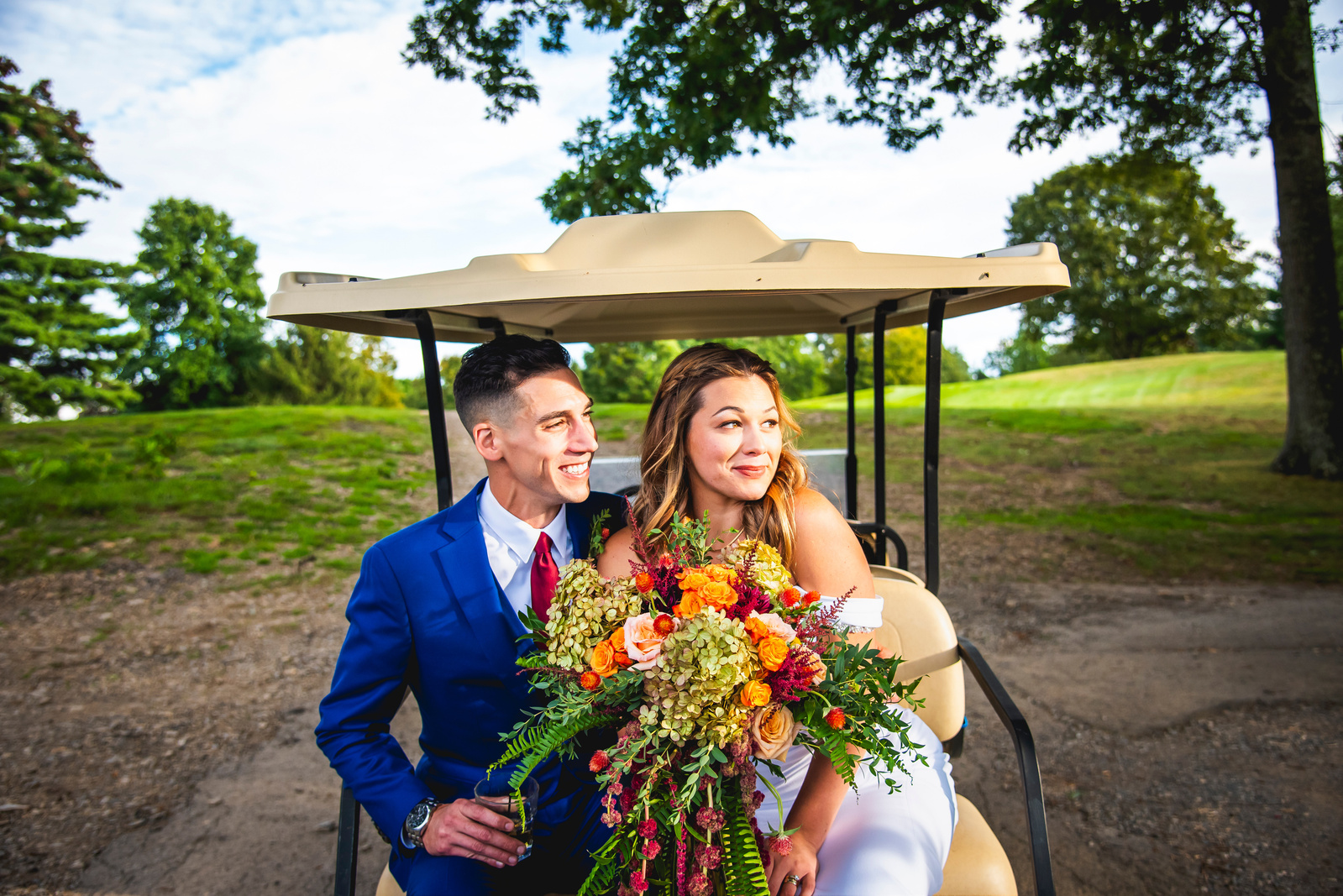 Bride and Groom sitting in the back of a golf cart in the Otterkill country club in Campbell hall, NY. 