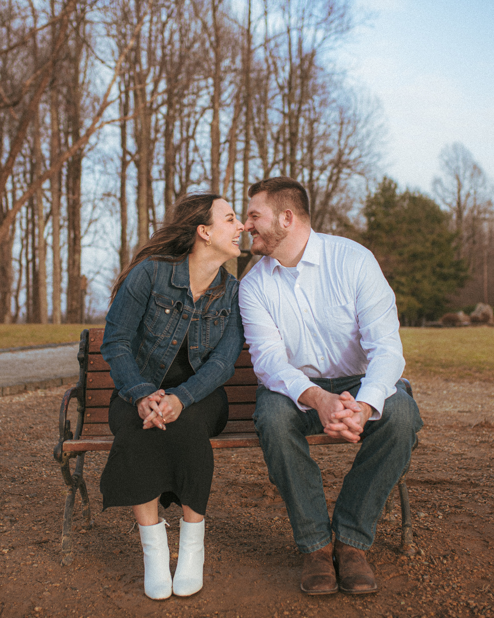 A couple laughing near sunset at Jump Off Rock in Hendersonville, NC during an engagement photography session