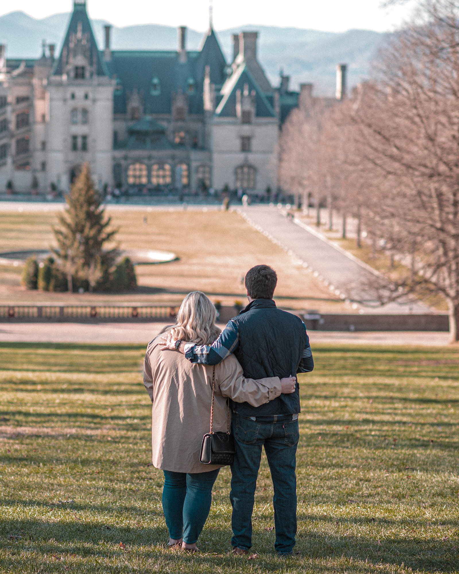 A couple stands overlooking the Biltmore Estate in Asheville, NC just before their engagement.