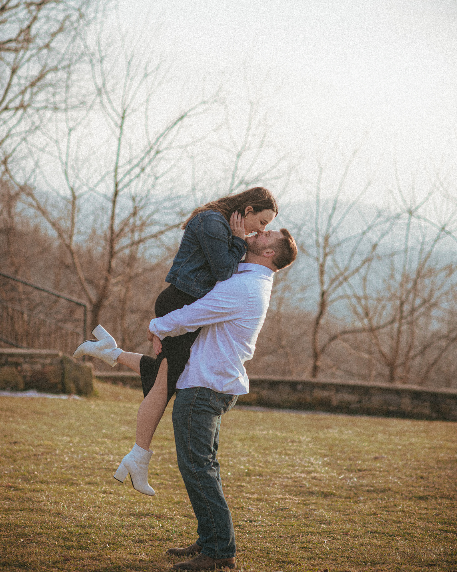 A couple kisses at Jump Off Rock in Hendersonville, NC during an engagement photography session