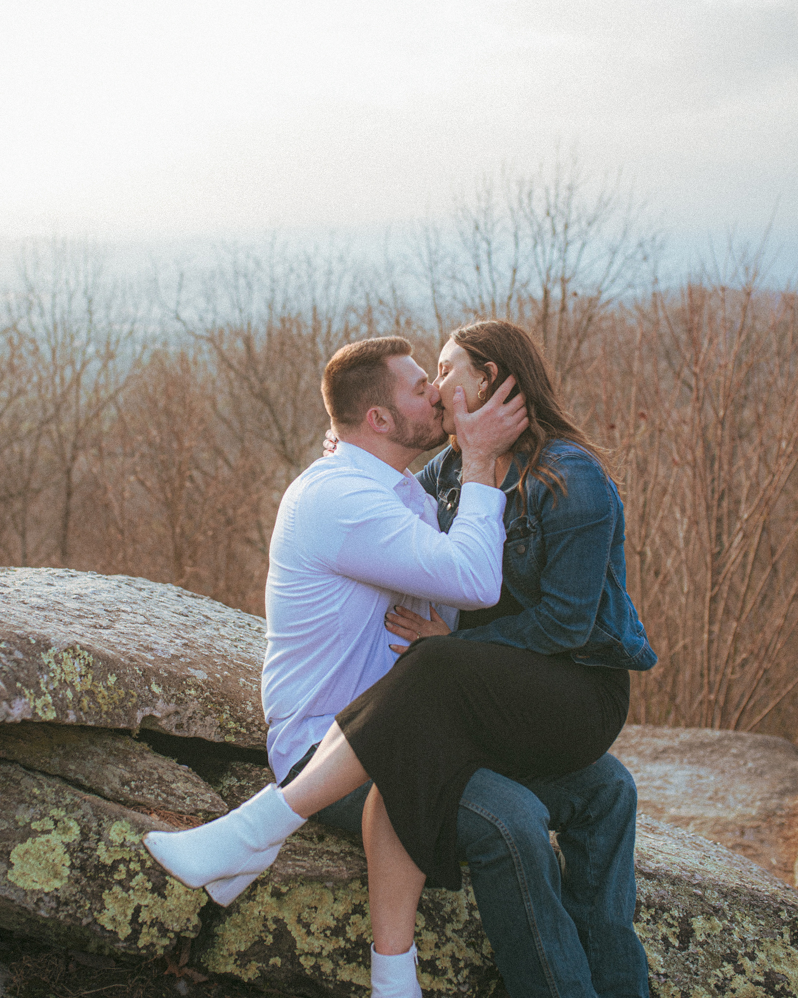 A couple kisses at Jump Off Rock in Hendersonville, NC during an engagement photography session