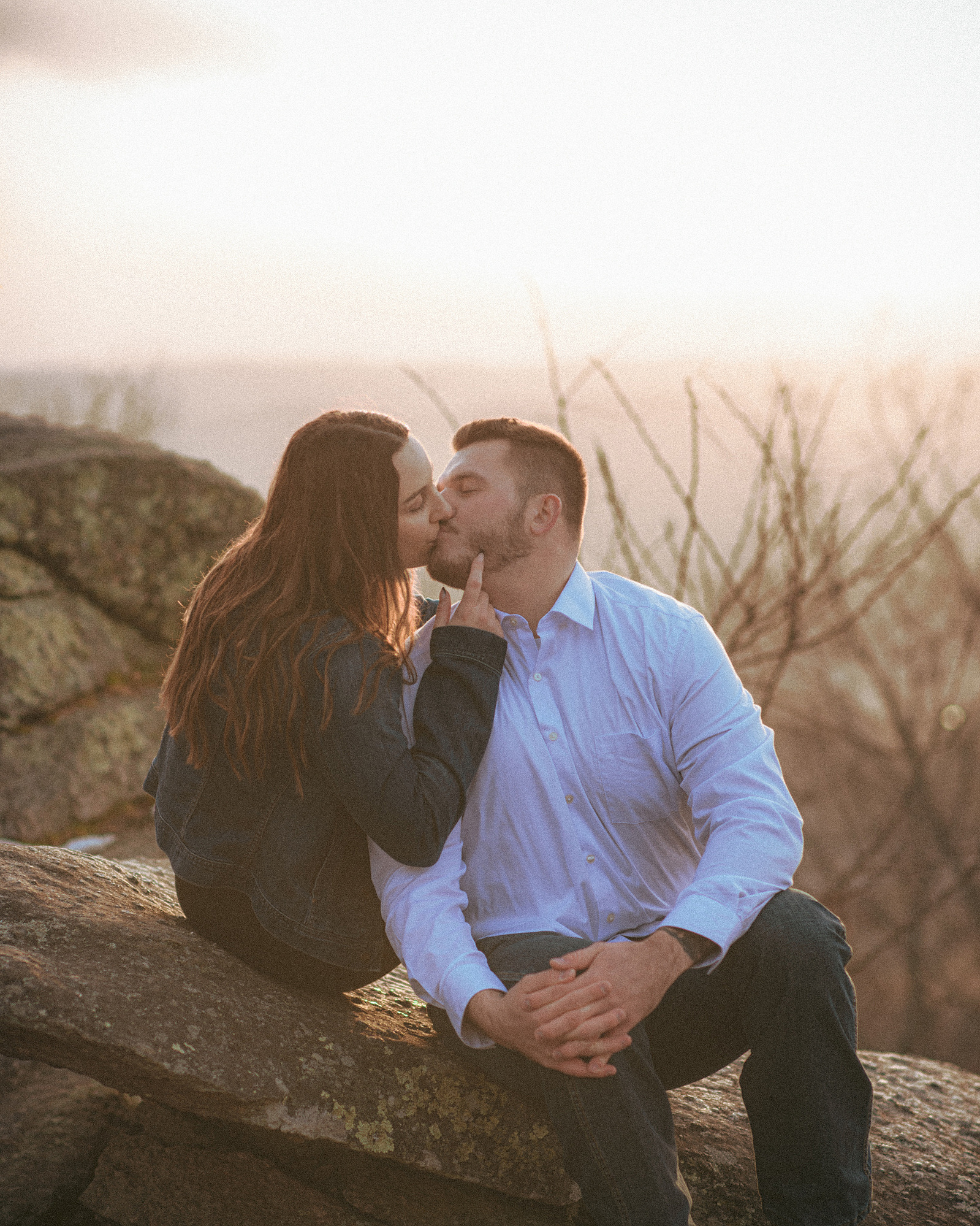 A couple kisses at Jump Off Rock in Hendersonville, NC during an engagement photography session