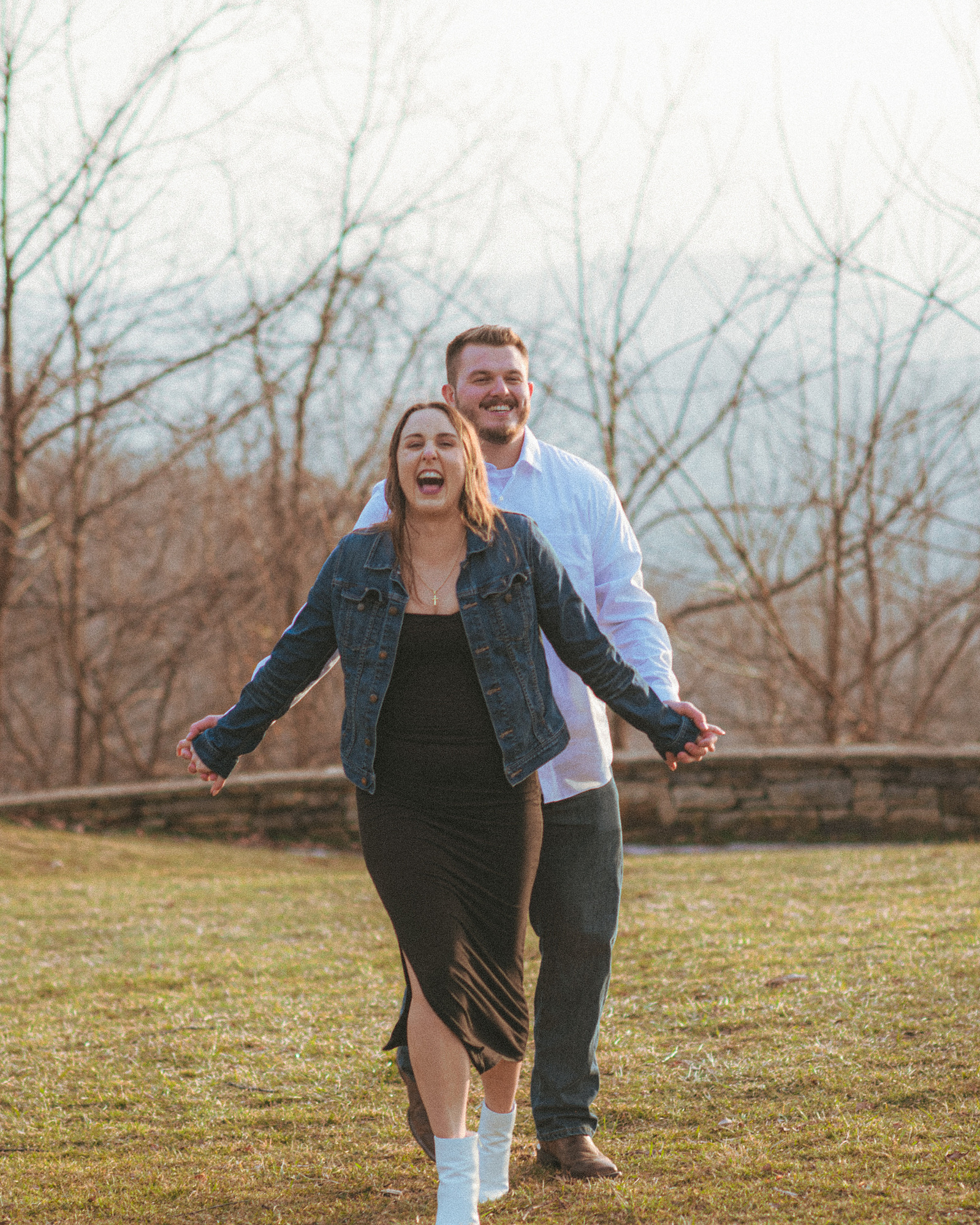 A couple laughing near sunset at Jump Off Rock in Hendersonville, NC during an engagement photography session