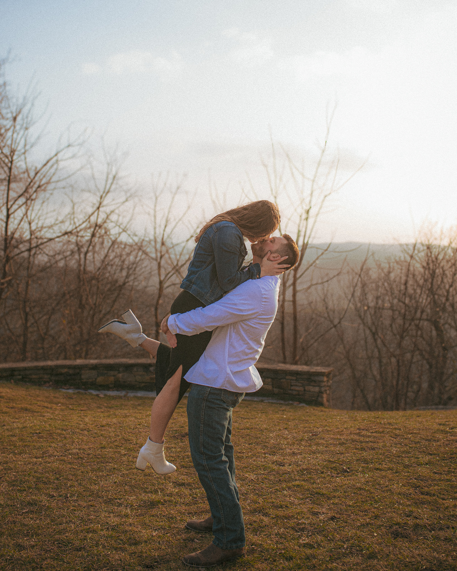 A couple kisses at Jump Off Rock in Hendersonville, NC during an engagement photography session