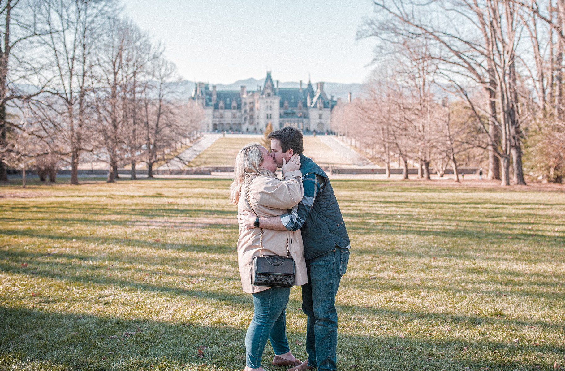 A couple shares a kiss after getting engaged at the Biltmore Estate in Asheville, NC