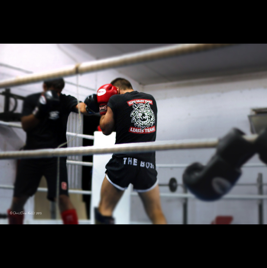 Muay Thai fighters spar in the ring wearing t-shirts with the logos of Siam Muay Thai Liasis Team, a Muay Thai school of martial arts in Cyprus.