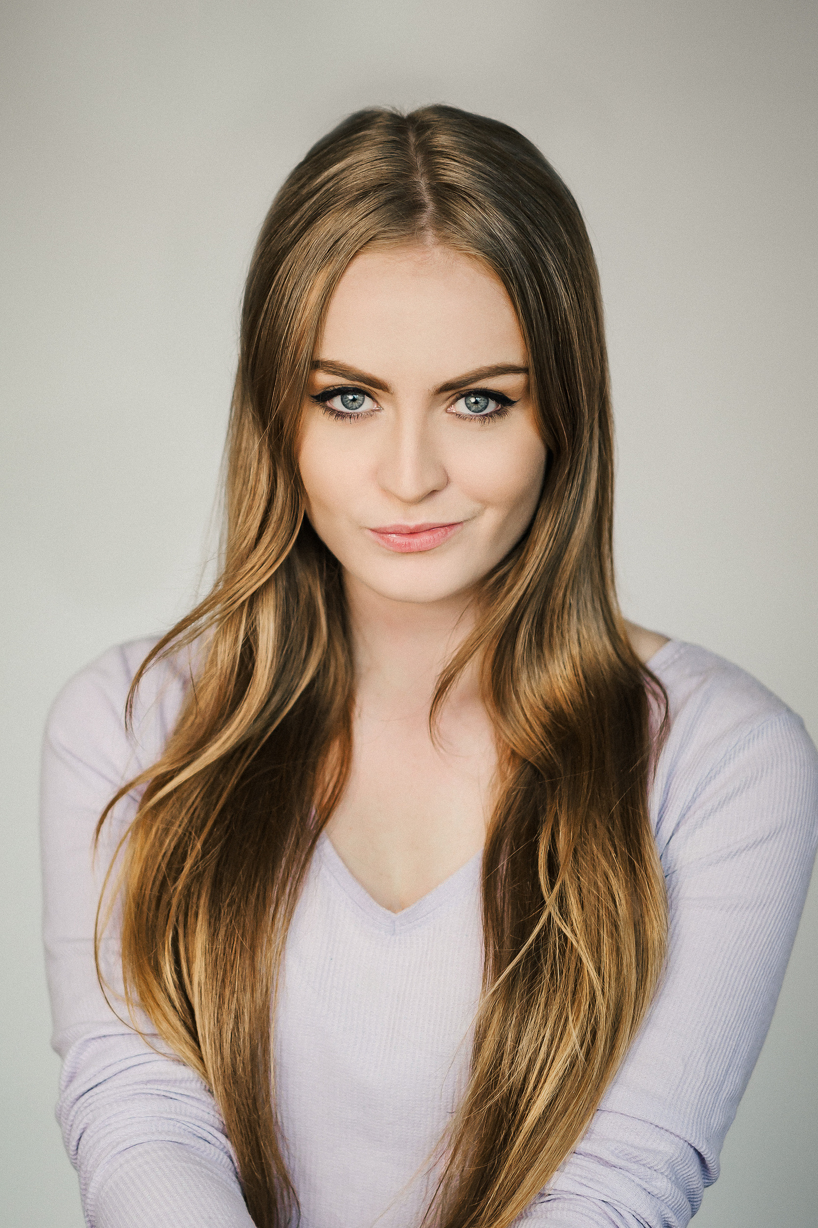 Headshot of a female Brisbane actor on a medium grey background