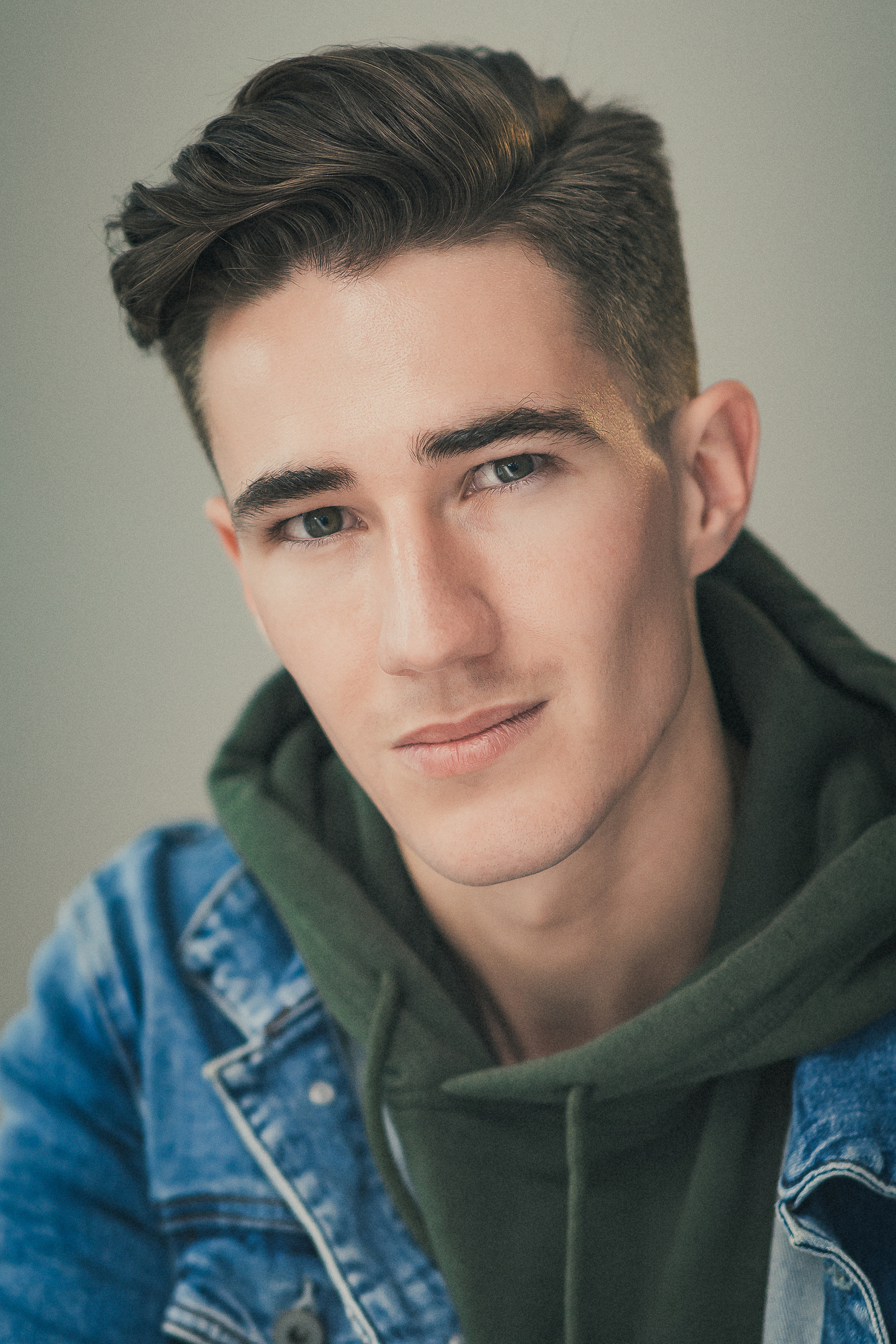 Headshot of a male Brisbane actor on a medium grey background