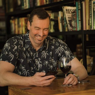 Dating profile photos of a single man in a bar with a glass of red wine