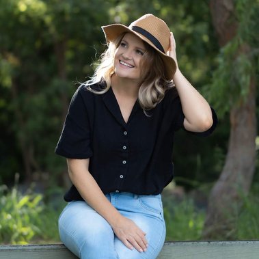 A single girl's dating profile photo wearing a hat and smiling