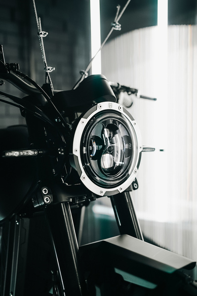 Detail photograph of a Mutt Motorcycles front headlight on a motorbike in their Birmingham HQ. Shot by Rob Senior