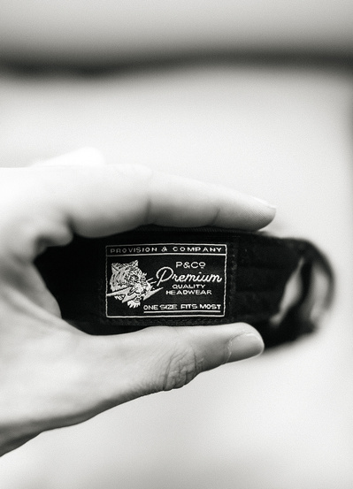 A close up detail photograph of the label on the back of a cap ensuring Quality manufacturing by Birmingham based apparel brand P&Co