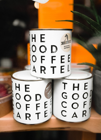 A Shop window with Three tins of coffee beans roasted by The Good Coffee Cartel who are based in Glasgow Scotland. 