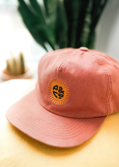 A cap with a sun logo on the front and text that reads P&Co