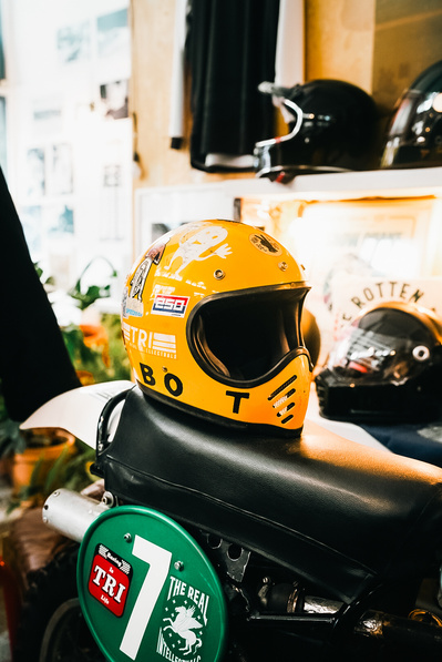 A yellow full face motorcycle helmet on a motorbike seat in a shop in Athens called The Real Intellectuals (TRI) Shot by Rob Senior