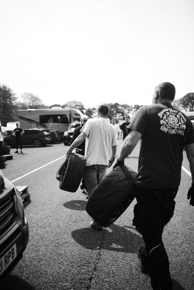car tyres being carried to a race car at a race circuit 
