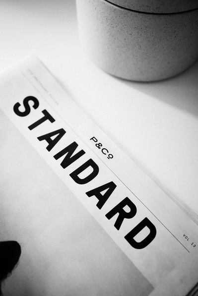 A top down photograph of a newspaper on a desk by Birmingham based clothing brand P&Co with large letters across the top saying "Standard" the title of the newsletter.