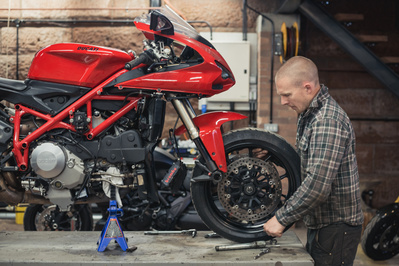 motorcycle mechanic taking the wheel off a Ducati motorbike