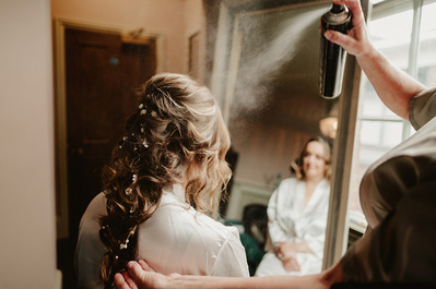 Bride, having her hair sprayed with hairspray at the vines of Rochester