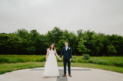 Bride and groom at Chapel house estate standing on the helicopter pad Holding Hands