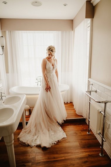 bride in a bathroom posing for a candid photo at the hythe imperial wedding venue in kent