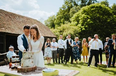bride and groom cutting their wedding cake at the paper mill in kent woodland