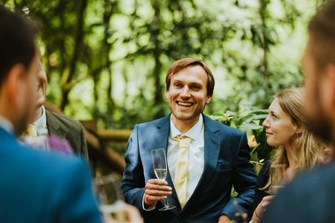 guests laughing and joking at the wedding in the forest