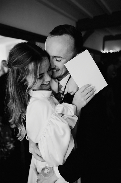 Groom and bride in brace in black-and-white photo after wedding speeches