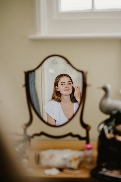 Gorgeous Bride getting her make up done through a mirror 