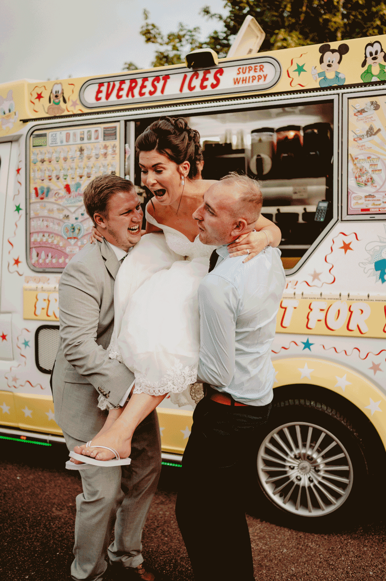 a  bride is being carried out of an ice cream van during relaxed kent wedding day