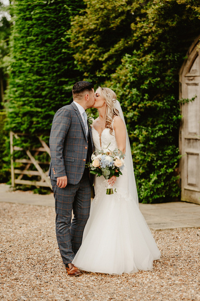 bride and groom share a quick kiss outside at winters barns