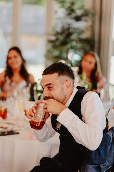 man laughs during the wedding speeches in the outdoor area at the night yard
