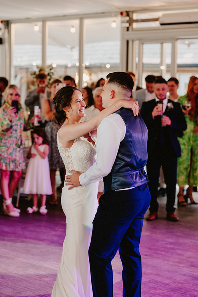 first dance at the night yard between the bride and groom with purple lighting