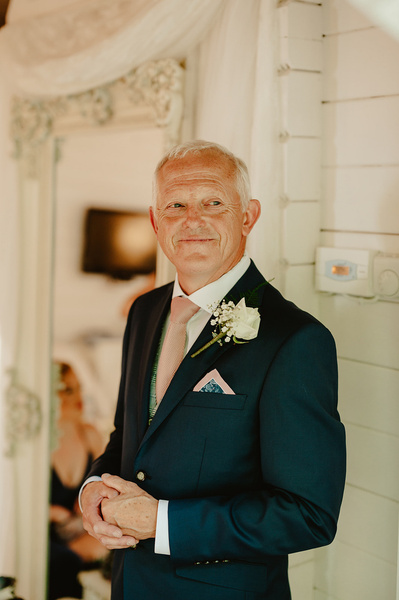 Father of the bride smiling indoors at marleybrook house