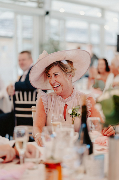 Mother of the bride laughing during wedding speeches at the night yard
