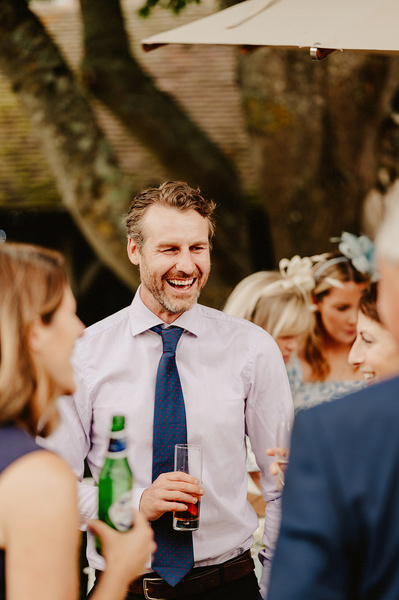 male wedding guest laughs during drinks reception at winters barns