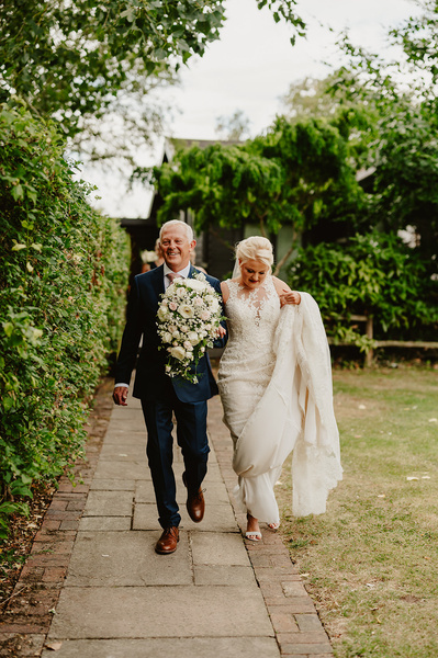 Bride and her father walking towards ceremony area at Marleybrook House