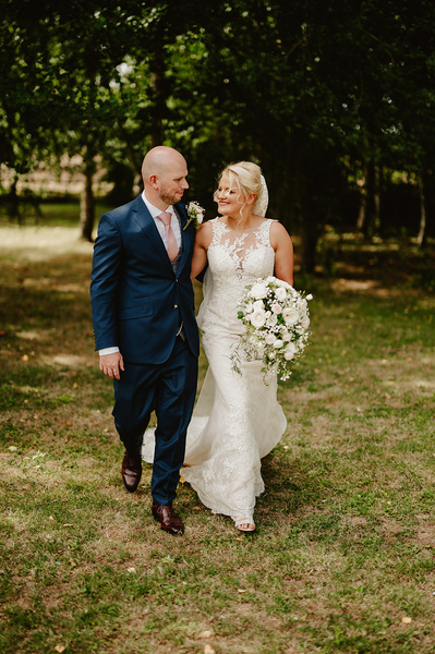 Bride and groom walking together while smiling at Marleybrook House