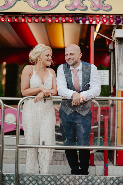 Relax photo of the bride and groom standing in front of the rollercoaster at Marleybrook House