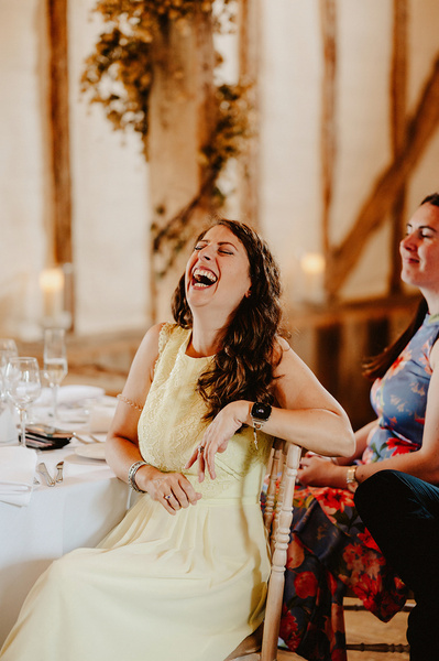 female wedding guest laughing uncontrollably during speeches at winters barns