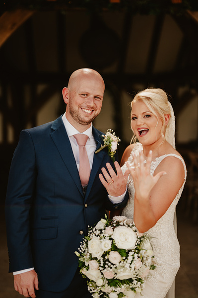 Bride and groom on her wedding day at Marleybrook House showing off their wedding rings whilst laughing