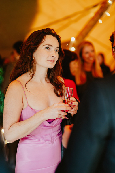 Candid photograph of female wedding guest in a pink dress in Kent