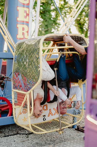 Bride and groom upside down on a ride at Marleybrook House