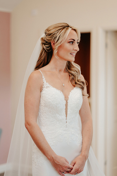 Bride and her wedding dress looking to her left in the salon