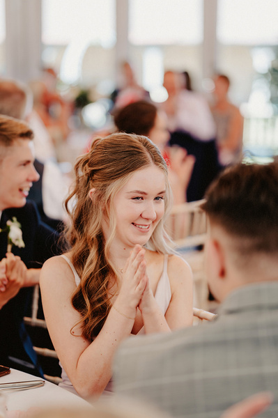 Guest laughs at her table during wedding reception at the night yard
