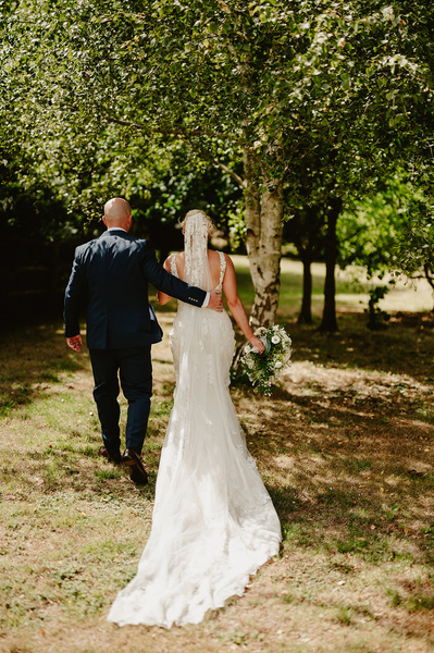 Bride and groom walking through the gardens at Marleybrook House