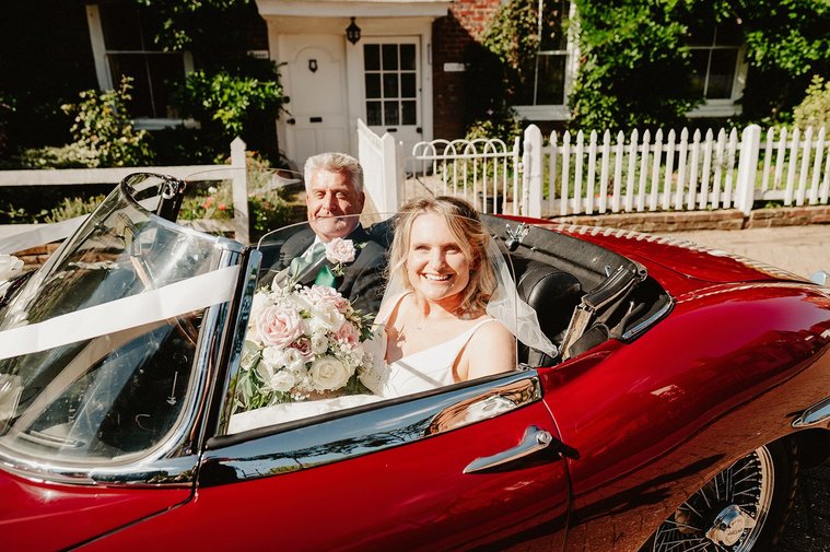 bride and her father in a sexy sports car before wedding ceremony