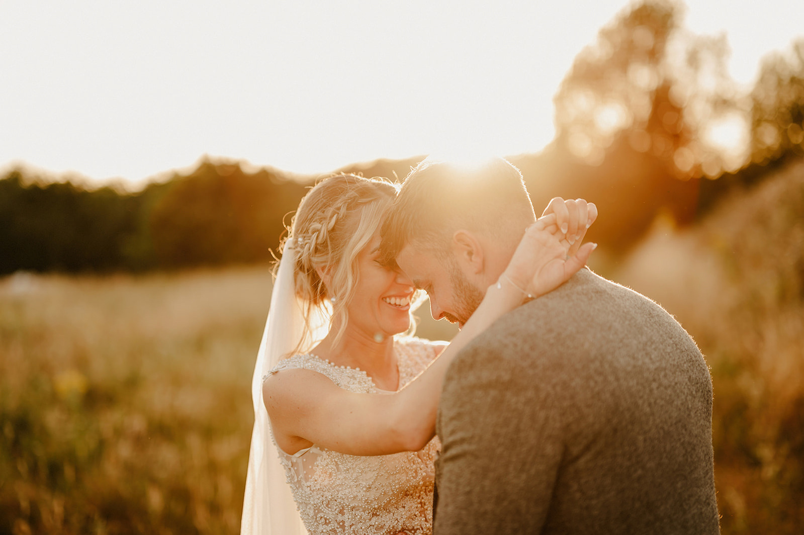 bride and groom at villiers barn in essex enjoying golden hour with brides arms round neck