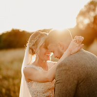 romantic wedding couple potrait during golden hour with bright lens flare 