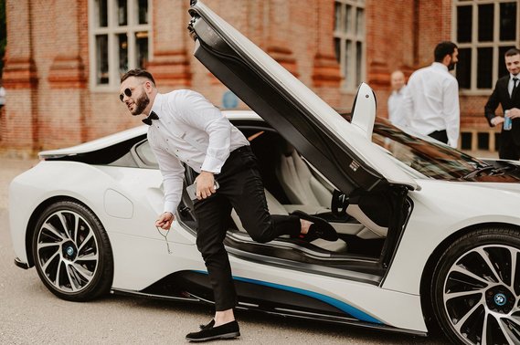 Groom jumping out of his sports car on the morning of his kent wedding day